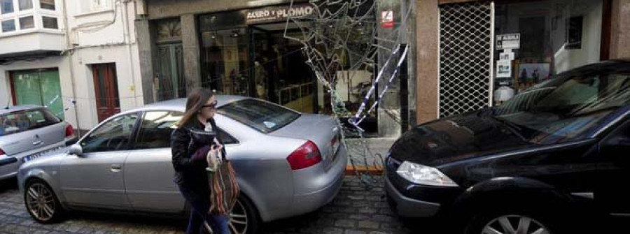 Cae una arcada de luz navideña sobre dos coches en el centro