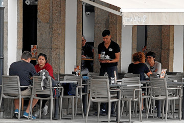 Un camarero atiende una terraza en un local de hostelería coruñés  AEC