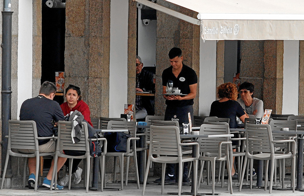 Un camarero atiende una terraza en un local de hostelería coruñés  AEC