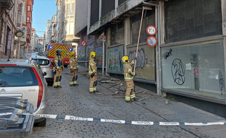 Los Bomberos de Ferrol retiran cascotes de la fachada lateral antiguo establecimiento Los Telares