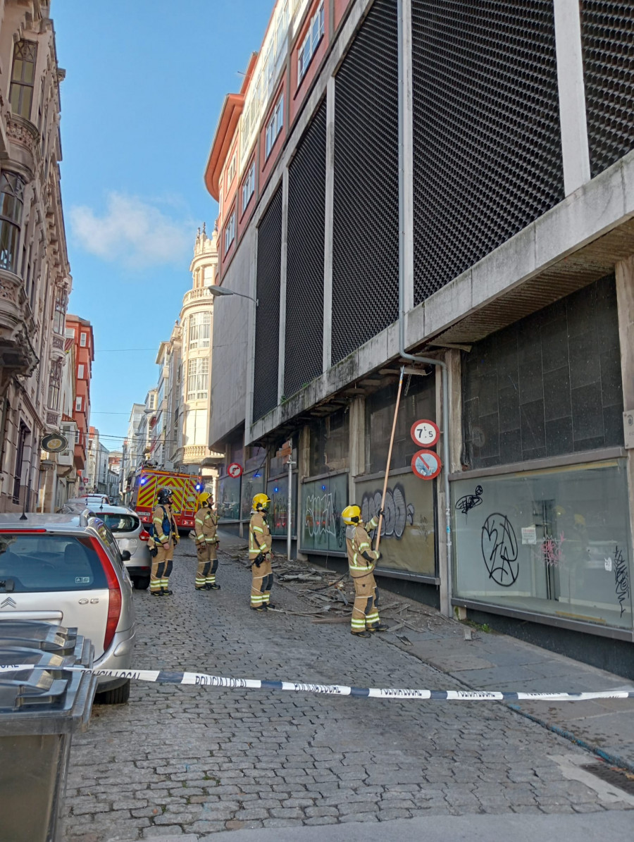 Los Bomberos de Ferrol retiran cascotes de la fachada lateral antiguo establecimiento Los Telares